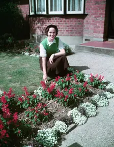 Woman proudly showing off her flower bed, c1955. Creator: Arthur Charles Kirby Ware