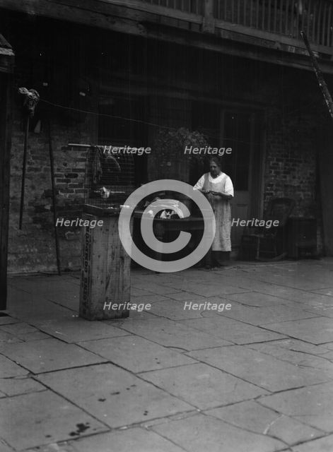 Woman working in a courtyard, New Orleans, between 1920 and 1926. Creator: Arnold Genthe.