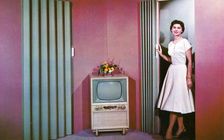 Woman walking into a room with a television, Janesville, Wisconsin, USA, 1955