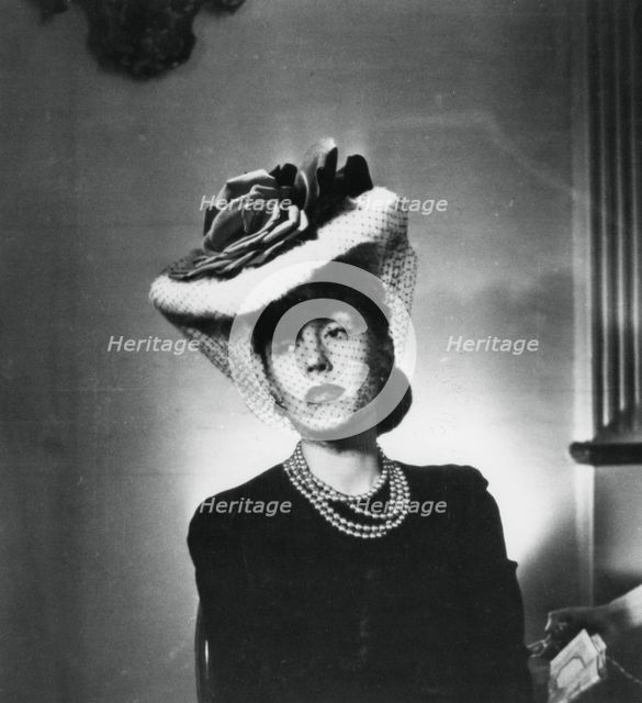 Woman wearing a hat and veil by the French fashion designer Jacques Fath, France, 1943. Artist: Unknown