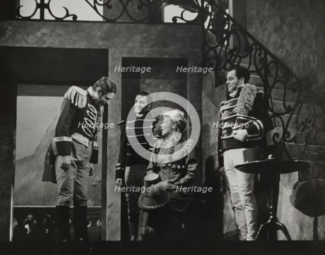 Woman with hat on knee talking to three men, 1938. Creator: Unknown.