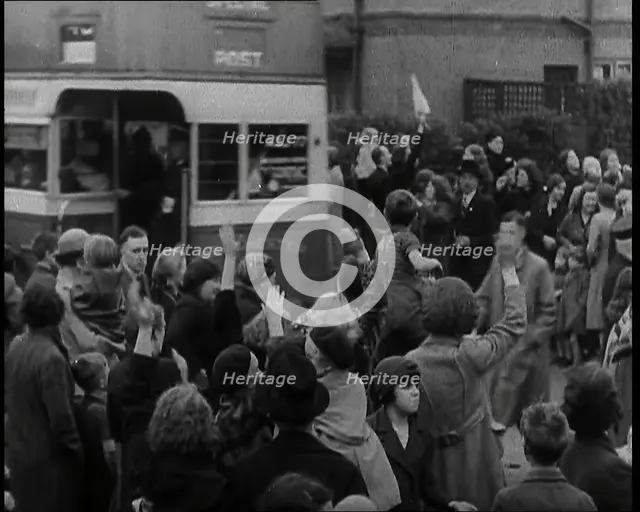 Women, Children, and Men Waving Goodbye to Children Being Evacuated by Bus, 1939. Creator: British Pathe Ltd.