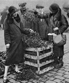 Women choosing bunches of mistletoe, Caledonian Market, London, 1926-1927