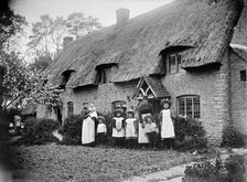 Women and children outside a thatched cottage, Marsh Gibbon, Buckinghamshire, 1904. Artist: Alfred Newton & Sons