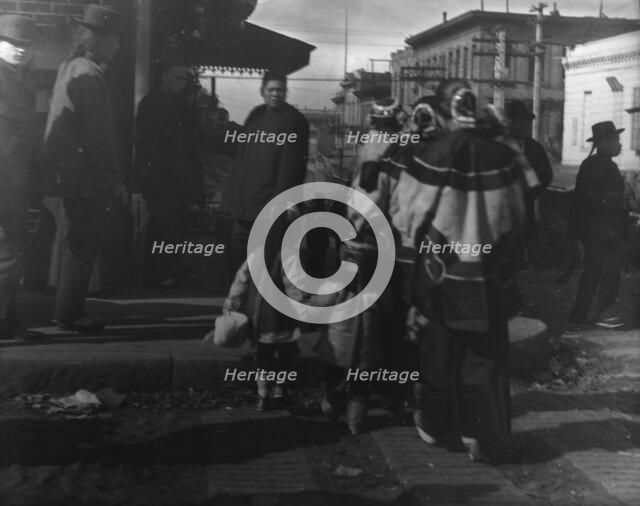 Women and children crossing a street, Chinatown, San Francisco, between 1896 and 1906. Creator: Arnold Genthe.