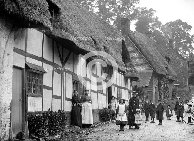 Women and children posing outside a thatched cottage, Ramsbury, Wiltshire, c1860-c1922. Artist: Henry Taunt