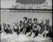 Women and Children Sitting on a Groyne, Splashing With Their Feet on a British Beach, 1920. Creator: British Pathe Ltd