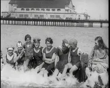 Women and Children Sitting on a Groyne, Splashing With Their Feet on a British Beach, 1920. Creator: British Pathe Ltd