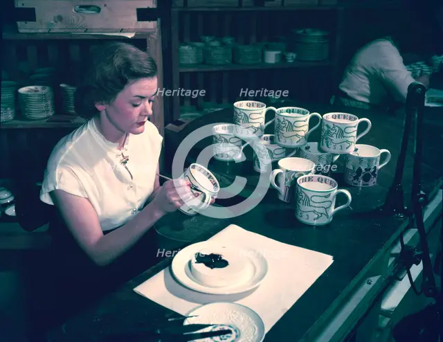Women hand-decorating souvenir mugs commemorating the Coronation of Queen Elizabeth II, 1953.  Creator: Arthur Charles Kirby Ware.
