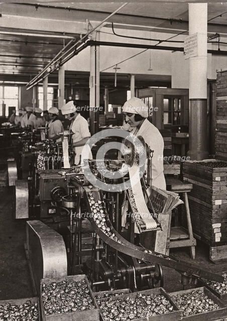 Women work on foiling machines, Rowntree factory, York, Yorkshire, 1933. Artist: Unknown