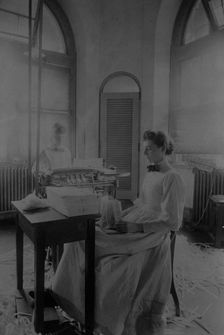 Women trimming and stacking currency sheets at the Bureau of Engraving & Printing, c1890. Creator: Frances Benjamin Johnston