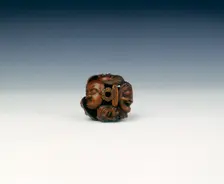 Wooden netsuke of seven Noh masks, late Edo period, Japan, 19th century. Creator: Koyosai