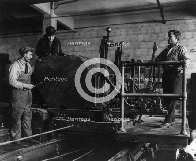 Wooden box industry - Mrs. Graham inspecting log on machinery with two workmen standing by, c1910. Creator: Frances Benjamin Johnston.