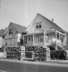 Woodpiles along the street are a characteristic of Portland, Oregon, 1939. Creator: Dorothea Lange