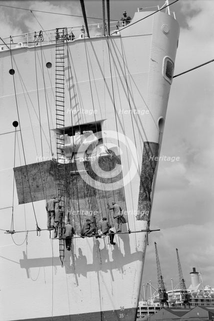 Workmen repairing the bow of a ship in London docks, c1945-c1965. Artist: SW Rawlings