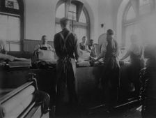 Workers wetting sheets prior to printing paper money at the Bureau of Engraving & Printing, c1895. Creator: Frances Benjamin Johnston