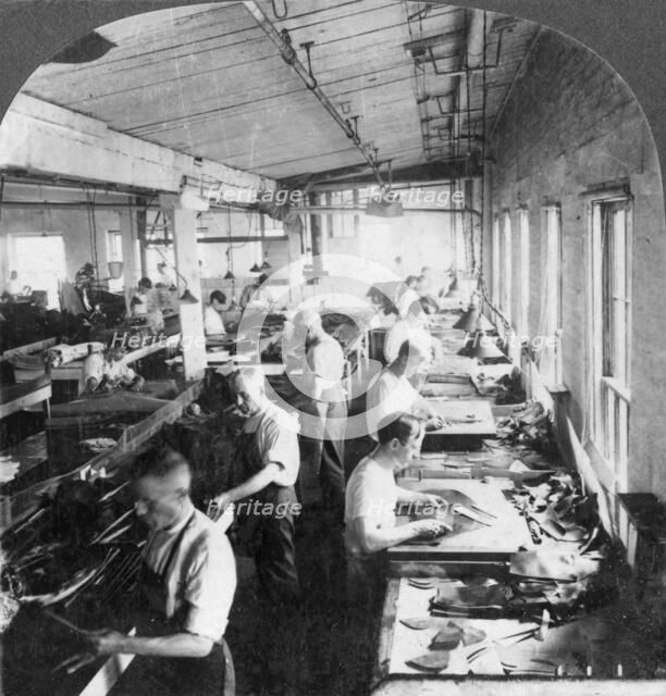 Workers cutting leather for shoes in a factory, Lynn, Massachusetts, USA, 20th century. Artist: Keystone View Company