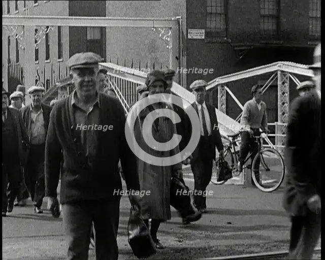 Workers Leaving Factory Through Factory Gates Which Are Closed After Them, 1932. Creator: British Pathe Ltd.
