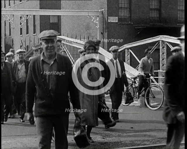 Workers Leaving Factory Through Factory Gates Which Are Closed After Them, 1932. Creator: British Pathe Ltd.
