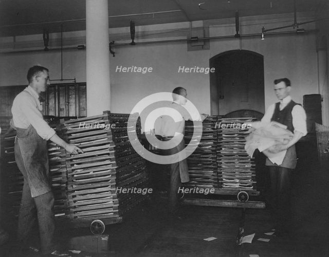 Workers moving newly printed currency into a drying box where sheets will dry before...c1890. Creator: Frances Benjamin Johnston.