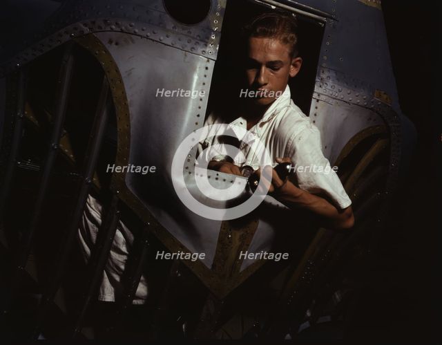 Working inside the nose of a PBY, Elmer J. Pace is learning the...Corus Christi, Texas, 1942. Creator: Howard Hollem.
