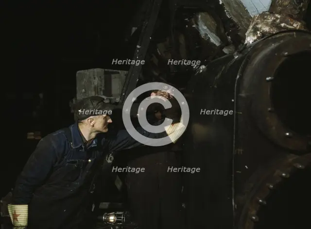 Working on the cylinder of a locomotive at the C & NW RR, 40th Street shops, Chicago, Ill., 1942. Creator: Jack Delano.