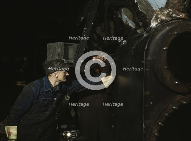 Working on the cylinder of a locomotive at the C & NW RR, 40th Street shops, Chicago, Ill., 1942. Creator: Jack Delano.