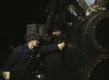 Working on the cylinder of a locomotive at the C & NW RR, 40th Street shops, Chicago, Ill., 1942. Creator: Jack Delano