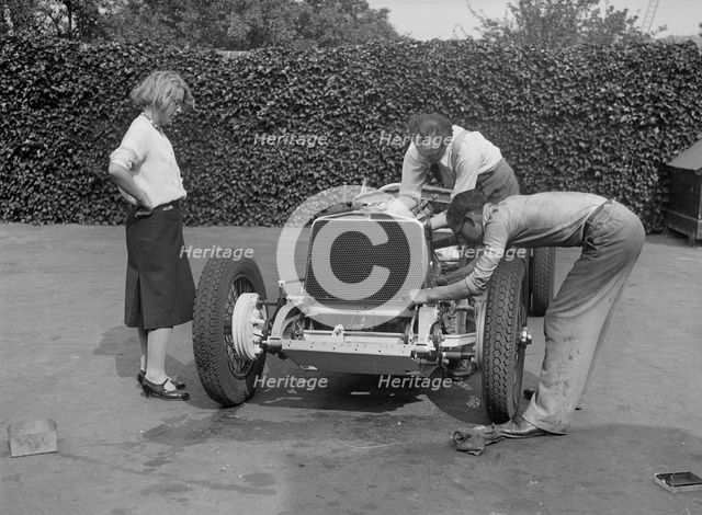 Working on the engine of Raymond Mays' Vauxhall-Villiers, c1930s. Artist: Bill Brunell.