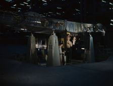 Working on the wing center section at the Consolidated Aircraft Corp..., Fort Worth, Texas, 1942. Creator: Howard Hollem