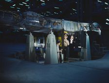 Working on wing of Consolidated Liberator..., Consolidated Aircraft Corp., Fort Worth, Texas, 1942. Creator: Howard Hollem