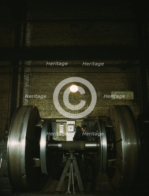 Worn tires on locomotive wheels are refaced on this machine in the wheel shop..., Chicago, 1942. Creator: Jack Delano.