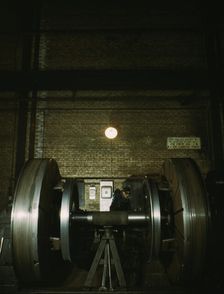 Worn tires on locomotive wheels are refaced on this machine in the wheel shop..., Chicago, 1942. Creator: Jack Delano