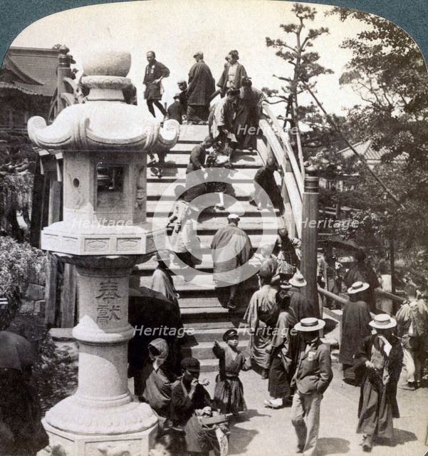 Worshippers crossing the semi-circular bridge to Kameido Temple beyond, looking north, Tokyo, Japan,Artist: Underwood & Underwood