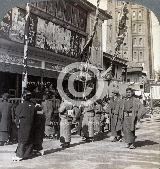 Watching a free show on Theatre Street, looking north to Asakusa Tower, Tokyo, Japan, 1904. Artist: Underwood & Underwood