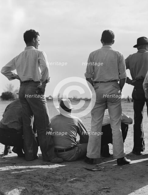 Watching ball game, Shafter camp for migrants, California, 1939. Creator: Dorothea Lange.