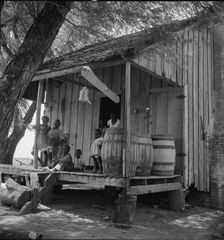 Water barrels on plantation cabin in Brazos riverbottoms, near Bryan, Texas, 1938. Creator: Dorothea Lange