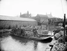 Waterman Abel Beesley on his punt full of bundles of rushes, Fisher Row, Oxford, Oxfordshire, 1901. Creator: Henry Taunt