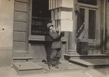 Wagon boy or "tail boy" helping to load the wagon, c. 1914. Creator: Lewis Wickes Hine