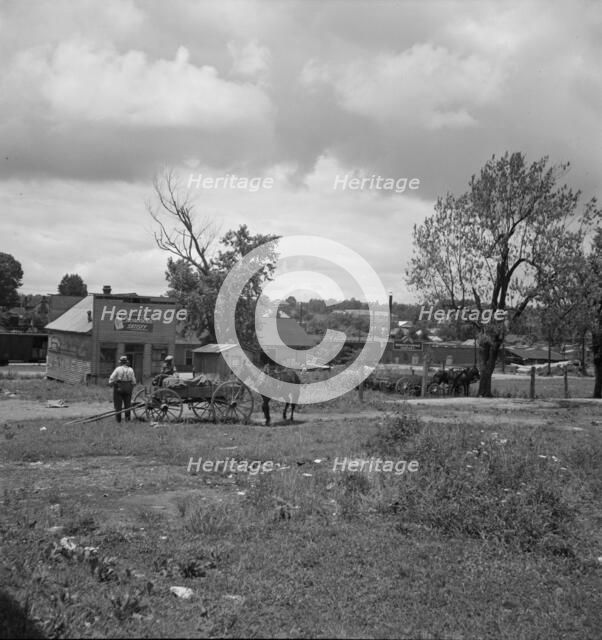 Wagons pulled up in field one block away from the main street, Siler City, North Carolina, 1939. Creator: Dorothea Lange.