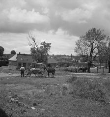 Wagons pulled up in field one block away from the main street, Siler City, North Carolina, 1939. Creator: Dorothea Lange