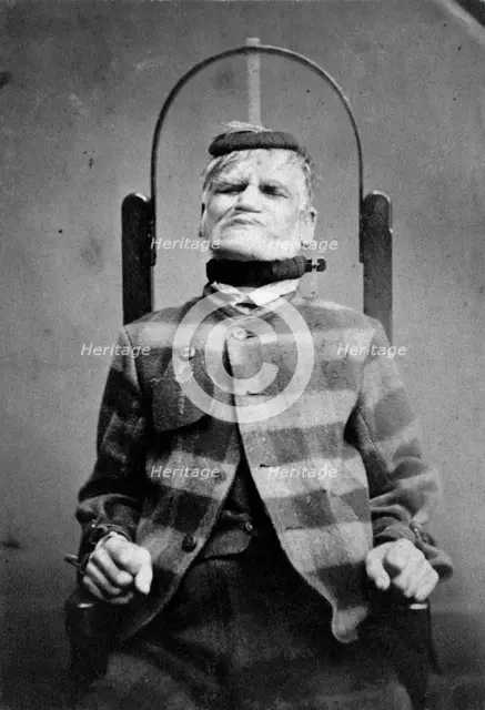 Wakefield Prison, Yorkshire: an elderly man, struggling against the restraint-chair in..., c1869. Creator: Unknown.
