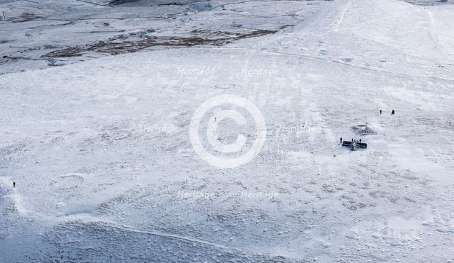 Walkers on a snowy Ingleborough Hillfort, with hut circle earthworks, North Yorkshire, 2018. Creator: Emma Trevarthen.