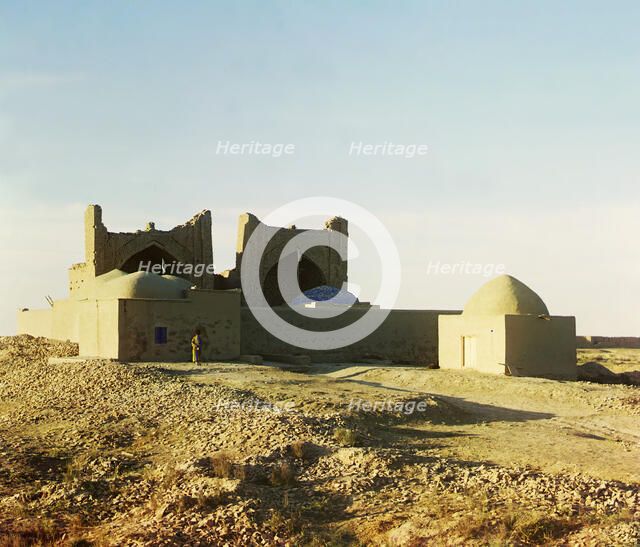 Walled adobe structure with domes and arches in desert area, with man posed..., between 1905-1915. Creator: Sergey Mikhaylovich Prokudin-Gorsky.