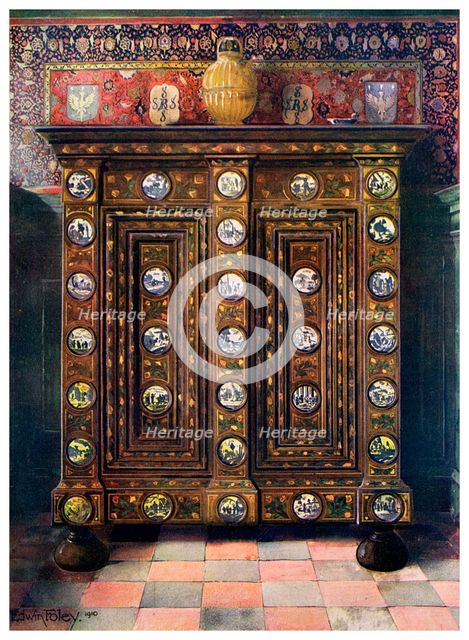 Walnut kas inlaid and with painted medallions of Delft ware, 1910.Artist: Edwin Foley