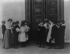 Washington, D.C. school children on field trip - examining the bronze "Columbus" door..., (1899?). Creator: Frances Benjamin Johnston