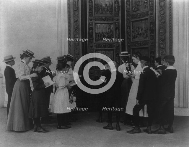 Washington, D.C. school children on field trip - examining the bronze "Columbus" door..., (1899?). Creator: Frances Benjamin Johnston.