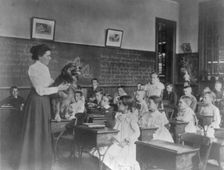 Washington, D.C. public schools, 5th Div. - teacher showing dog, (1899?). Creator: Frances Benjamin Johnston