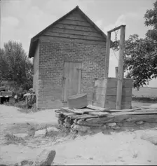 Well and old plantation smokehouse, Chesnee, South Carolina, 1937. Creator: Dorothea Lange
