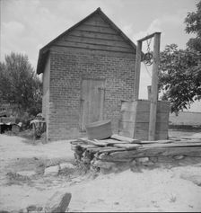 Well and old plantation smokehouse, Chesnee, South Carolina, 1937. Creator: Dorothea Lange
